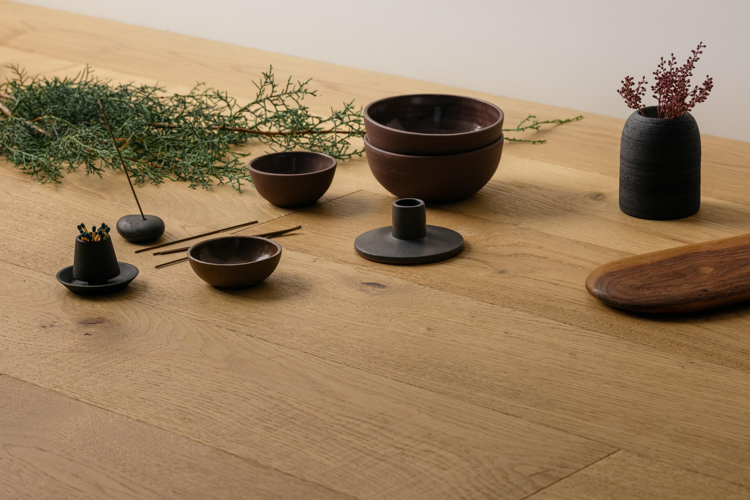 Angled view of the Cazador floor from the Bohemia collection from Kentwood Collection. On the floor are several brown bowls and decorative plants.